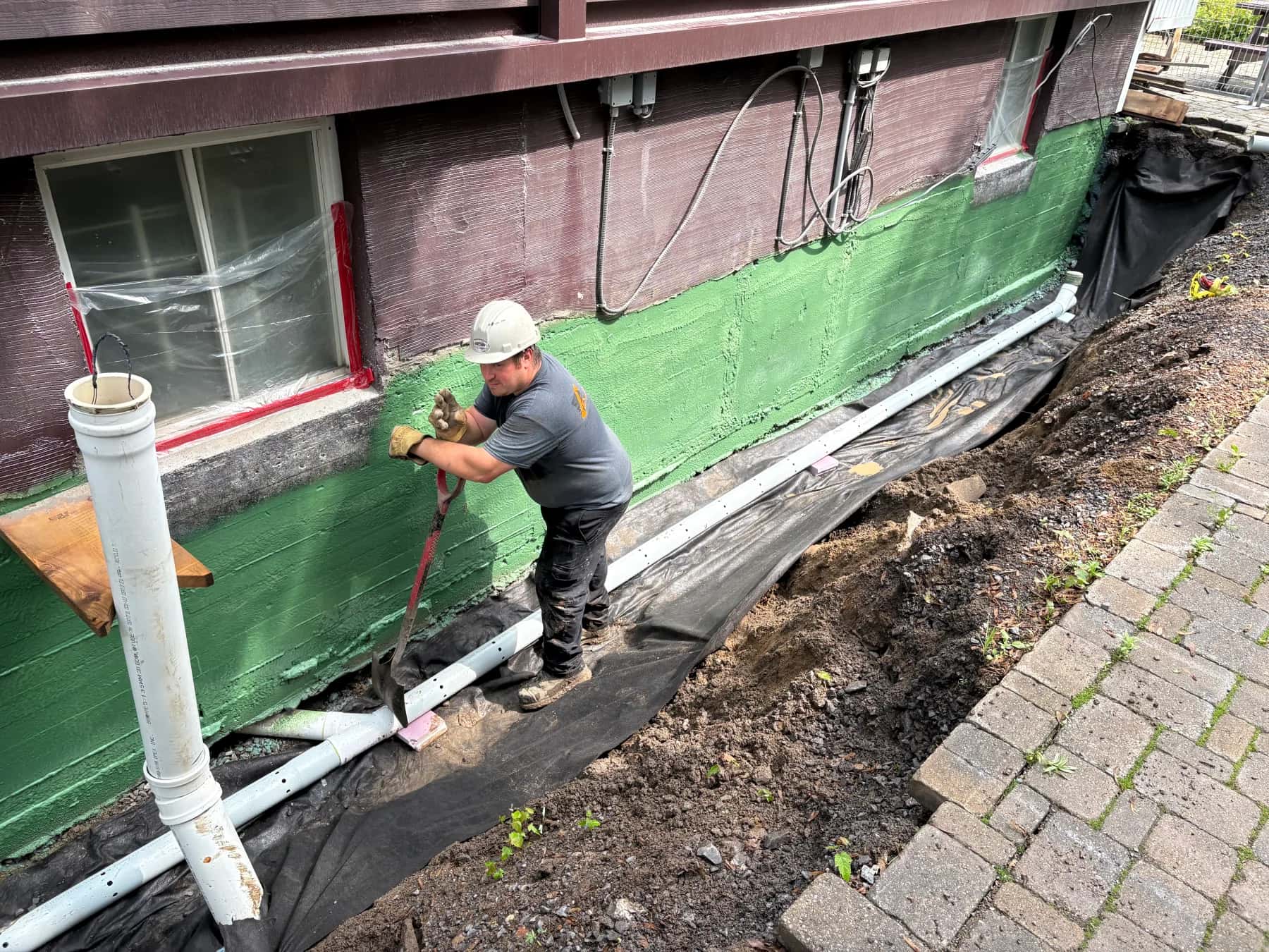 Installation d’un drain français et d’une membrane sur une fondation